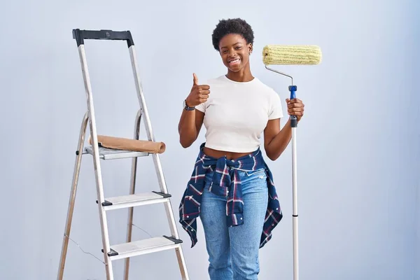 Mulher Afro Americana Segurando Pintor Rolos Fazendo Polegares Felizes Gesto — Fotografia de Stock