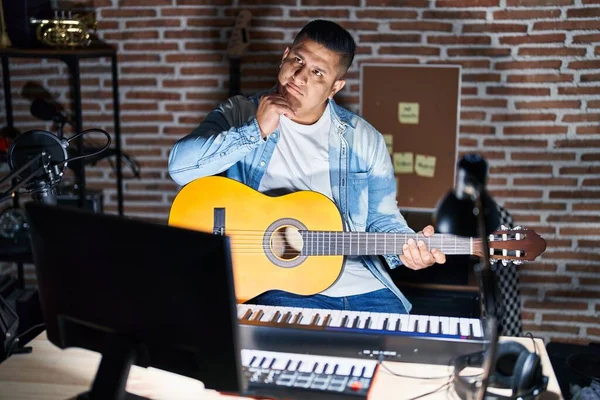 Hispán Fiatalember Klasszikus Gitáron Játszik Zenei Stúdióban Kéz Kézben Gondolkodva — Stock Fotó
