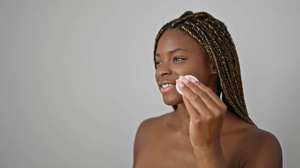 非洲裔美国妇女带着自信的笑容 用棉垫在孤立的白色背景上清洁脸 — 图库照片
