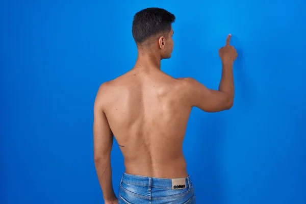 Joven Hombre Hispano Pie Sin Camisa Sobre Fondo Azul Posando —  Fotos de Stock