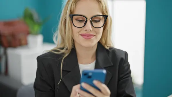 Young blonde woman business worker using smartphone working at the office