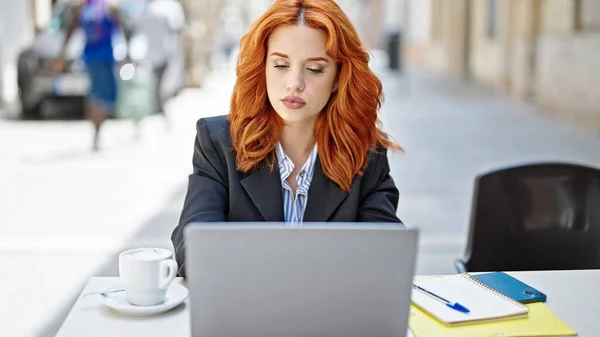 在咖啡店的阳台上 年轻的红头发女商人用笔记本电脑轻松地表达自己的想法 — 图库照片