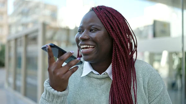戴辫子的非洲女人在街上用智能手机发送语音讯息 — 图库照片
