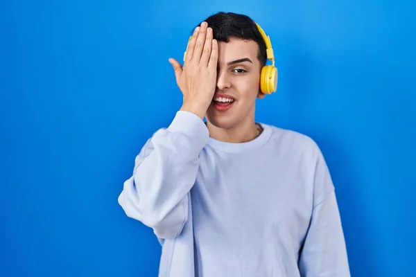 Δυαδικό Άτομο Που Ακούει Μουσική Χρησιμοποιώντας Ακουστικά Που Καλύπτουν Ένα — Φωτογραφία Αρχείου