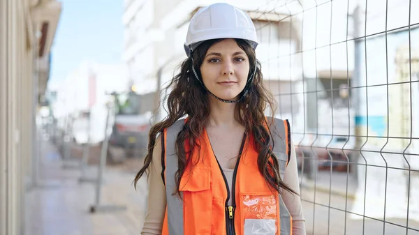 年轻美丽的惊慌失措的女建筑工人站在街上 满脸轻松的表情 — 图库照片