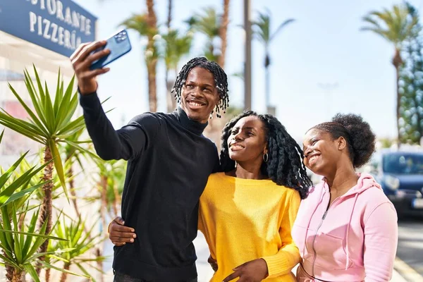 African american friends standing together making selfie by the smartphone at street