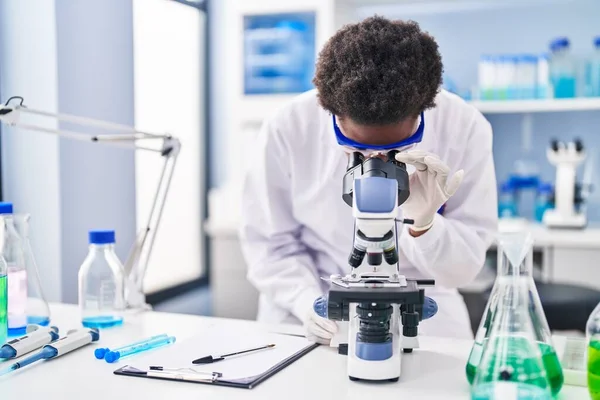 Afroamerykanka Mundurze Naukowca Używająca Mikroskopu Laboratorium — Zdjęcie stockowe