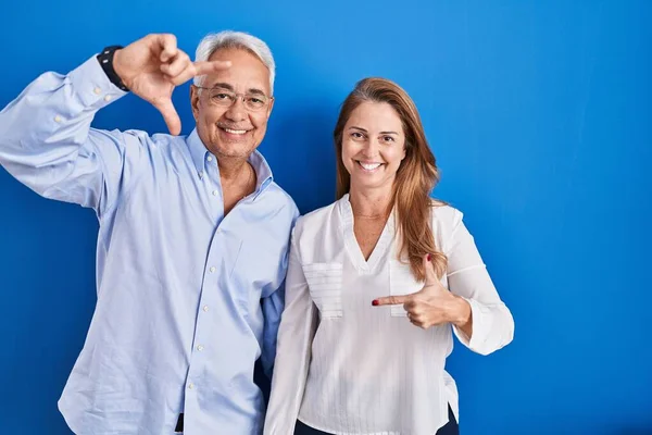 Orta Yaşlı Spanyol Çift Mavi Arka Planda Durup Gülümsüyor Mutlu — Stok fotoğraf