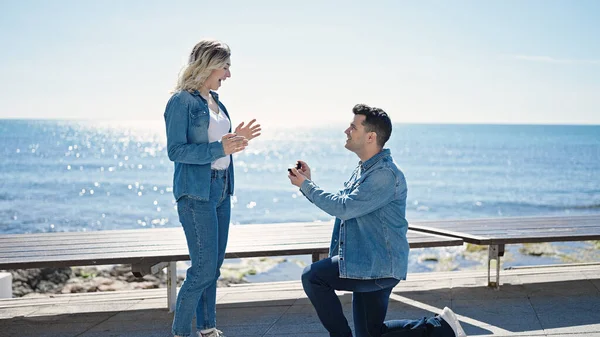 男性と女性のカップル笑顔自信を持って関与提案で海辺で — ストック写真