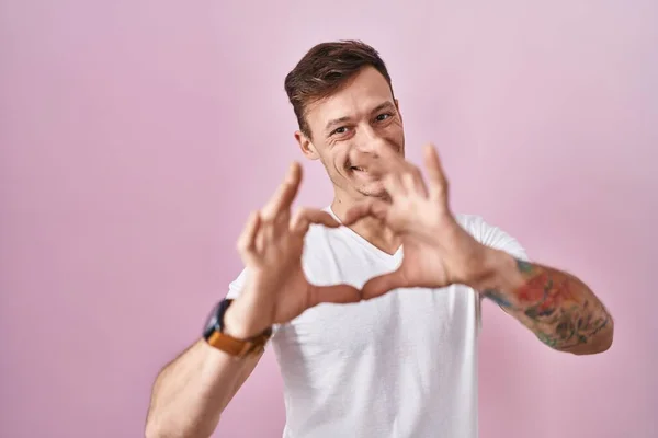 Blanke Man Staat Roze Achtergrond Glimlachend Liefde Doen Hart Symbool — Stockfoto