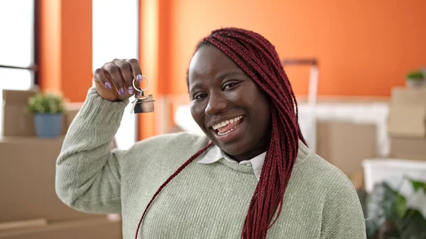 在新家 留着辫子的非洲女人自信地微笑着拿着钥匙 — 图库照片