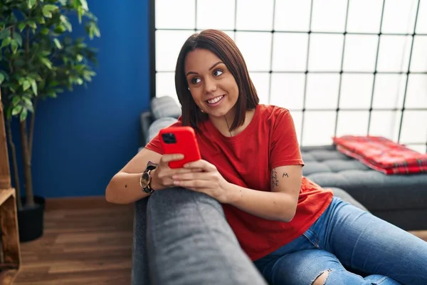 Young Beautiful Hispanic Woman Using Smartphone Sitting Sofa Home — Stock Photo, Image