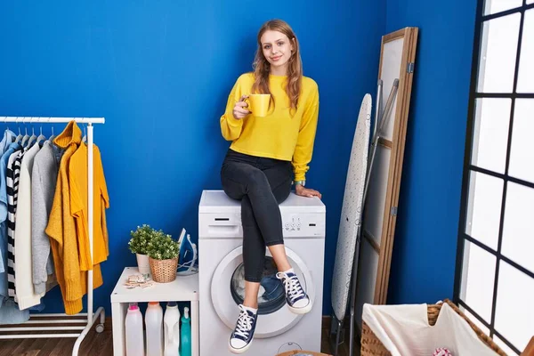 Young Blonde Woman Drinking Coffee Waiting Washing Machine Laundry Room — Stockfoto