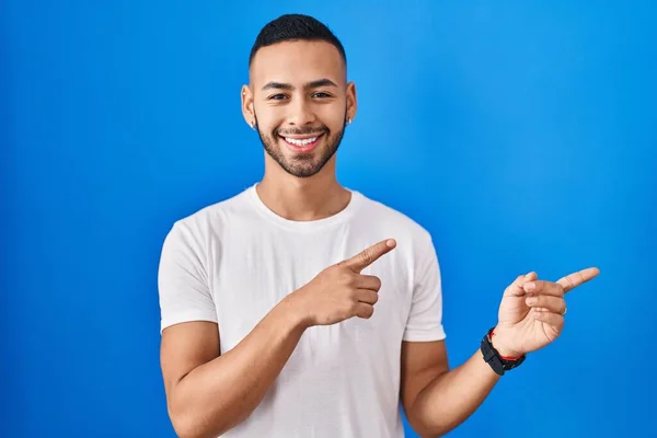 Young Hispanic Man Standing Blue Background Smiling Looking Camera Pointing — Fotografia de Stock