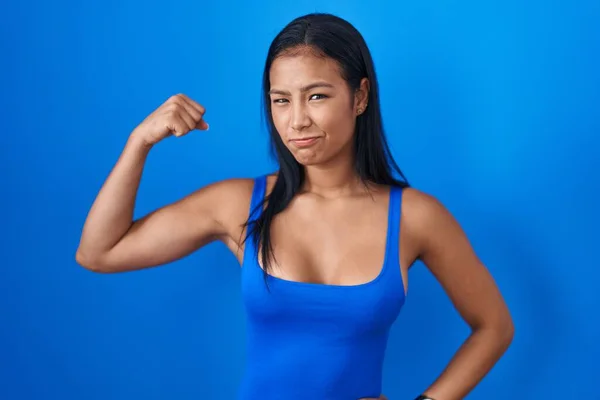 Hispanic Kvinna Står Över Blå Bakgrund Stark Person Visar Arm — Stockfoto