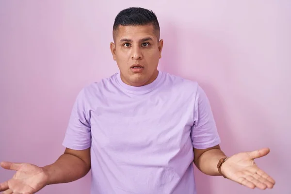 Young Hispanic Man Standing Pink Background Clueless Confused Open Arms — Stockfoto