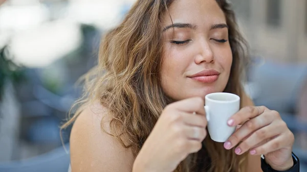 若い美しいですヒスパニック女性座っていますテーブルの上に臭いカップのコーヒー笑顔でコーヒーショップテラス — ストック写真