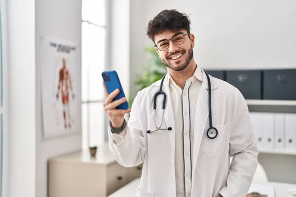 Jovem Hispânico Vestindo Uniforme Médico Usando Smartphone Clínica — Fotografia de Stock
