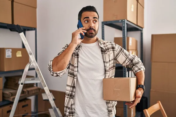 Young Hispanic Man Ecommerce Business Worker Talking Smartphone Holding Package — Stock Photo, Image