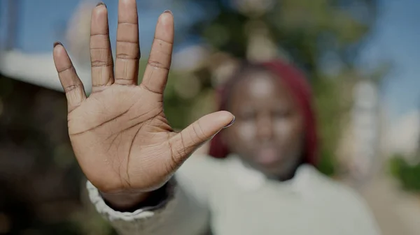 在街上用手拿着辫子的非洲女人做停止姿势 — 图库照片