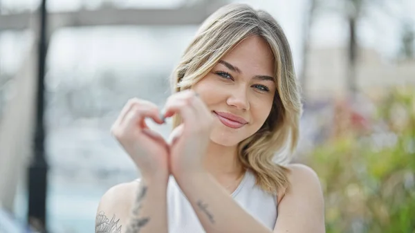 Young Blonde Woman Smiling Confident Doing Heart Gesture Hands Street — Foto Stock