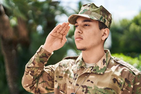 Young man army soldier saluting at street