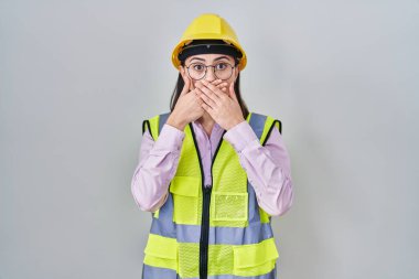 İspanyol kız müteahhit üniforması giyiyor ve kasketli şapka yanlışlıkla ağzı ellerle kapatıyor. gizli kavram. 