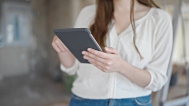 İnşaat alanında dokunmatik ped kullanan genç ve güzel bir İspanyol kadın.