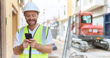Middle age man architect smiling confident using smartphone at street