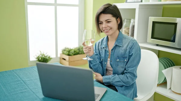 在家里用笔记本电脑喝酒的年轻高加索女人 — 图库照片