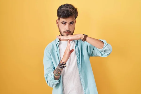 Young Hispanic Man Tattoos Standing Yellow Background Doing Time Out — Stock fotografie