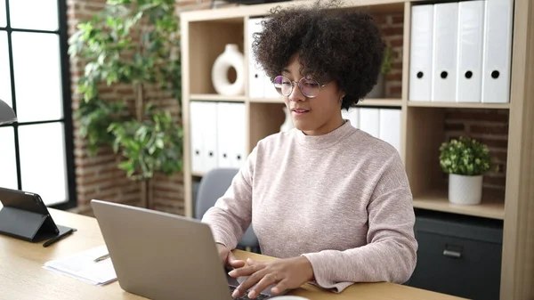 使用笔记本电脑在办公室工作的年轻的非洲裔美国女商人 — 图库照片