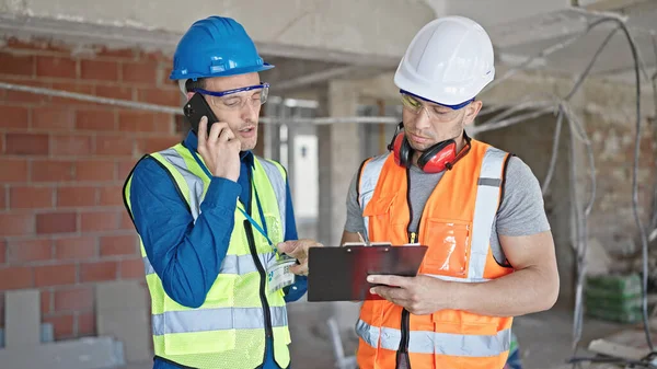 Dois Construtores Homens Escrevendo Documento Falando Smartphone Local Construção — Fotografia de Stock