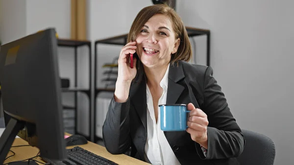 Mulher Hispânica Meia Idade Empresária Falando Telefone Bebendo Café Escritório — Fotografia de Stock