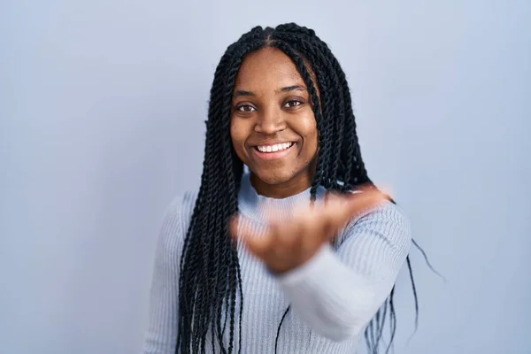 Afroamerikanerin Steht Vor Blauem Hintergrund Und Lächelt Fröhlich Und Bietet — Stockfoto