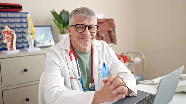 Klinikte Çalışırken Laptopunu Kullanan Orta Yaşlı Gri Saçlı Bir Adam — Stok fotoğraf