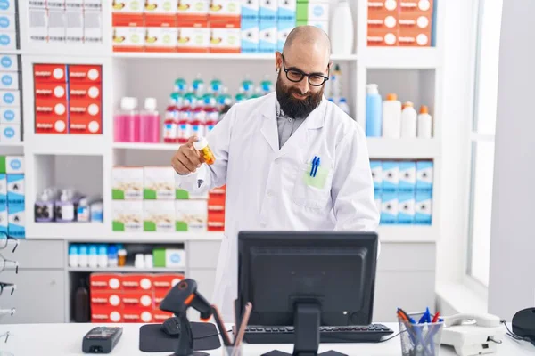 Young Bald Man Pharmacist Using Computer Holding Pills Bottle Pharmacy — Stock Photo, Image