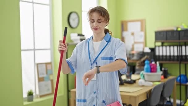 Młoda Kobieta Profesjonalny Sprzątaczka Patrząc Zegarek Sprzątanie Podłoga Uśmiechnięta Biurze — Wideo stockowe