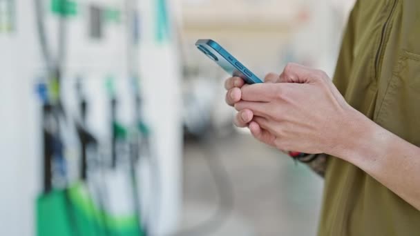 Jovem Hispânico Usando Smartphone Posto Gasolina — Vídeo de Stock