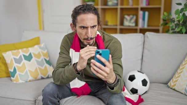 Jovem Hispânico Assistindo Jogo Futebol Smartphones Apoiando Casa — Vídeo de Stock