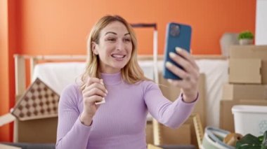 Genç, güzel, İspanyol bir kadın yeni evinde video görüşmesi yapıyor.