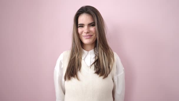 Молода Красива Іспаномовна Жінка Посміхається Впевнено Над Ізольованим Рожевим Тлом — стокове відео