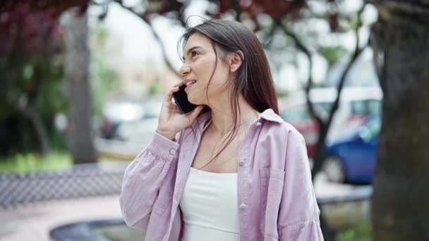 公園で真剣な表情でスマートフォンで話している若い美しいヒスパニック系の女性 — ストック動画