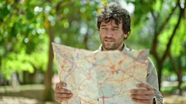 Νεαρός Ισπανός Τουρίστας Χαμογελά Αυτοπεποίθηση Κοιτάζοντας Χάρτη Στο Πάρκο — Αρχείο Βίντεο