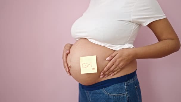 Młoda Kobieta Ciąży Wskazując Dziewczyny Przypomnienie Papieru Brzuchu Nad Odizolowanym — Wideo stockowe