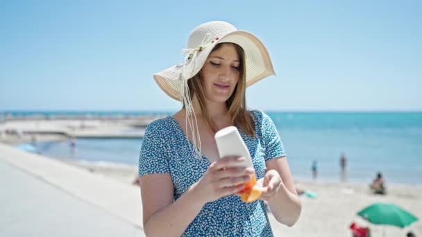 Junge Blonde Touristin Lächelt Selbstbewusst Und Trägt Sonnencreme Meer Auf — Stockvideo