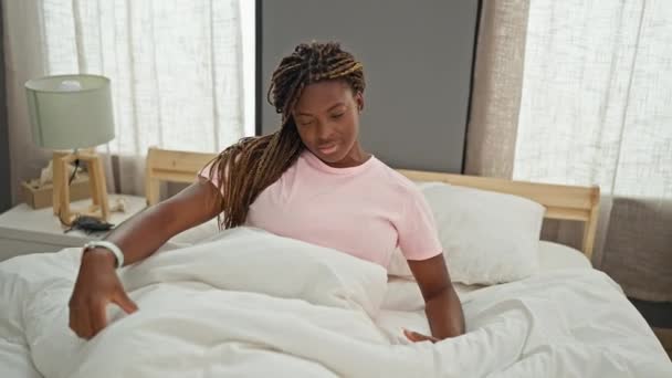 アフリカ系アメリカ人女性目覚めますストレッチ腕でベッドルーム — ストック動画