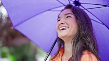 Parkta kendine güvenen güzel İspanyol kadın gülümsüyor.