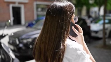 Madrid sokaklarında yürürken telefonda konuşan genç ve güzel İspanyol kadın.