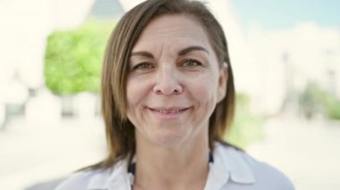 Middle age hispanic woman smiling confident at street